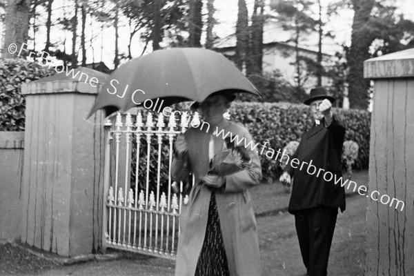 LADY WITH UMBRELLA AT PARK GATE, CLERIC ?? WITH RAISED FIST